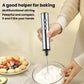 Handheld electric milk frother held in hand, mixing whisk head over froth