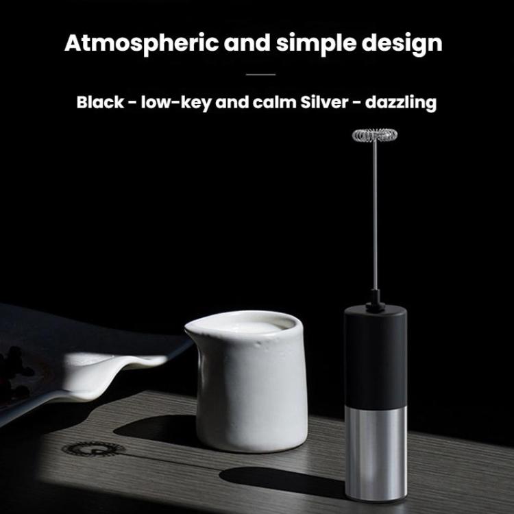 Electric milk frother whisk on black-and-silver handheld base, frothing in a cup