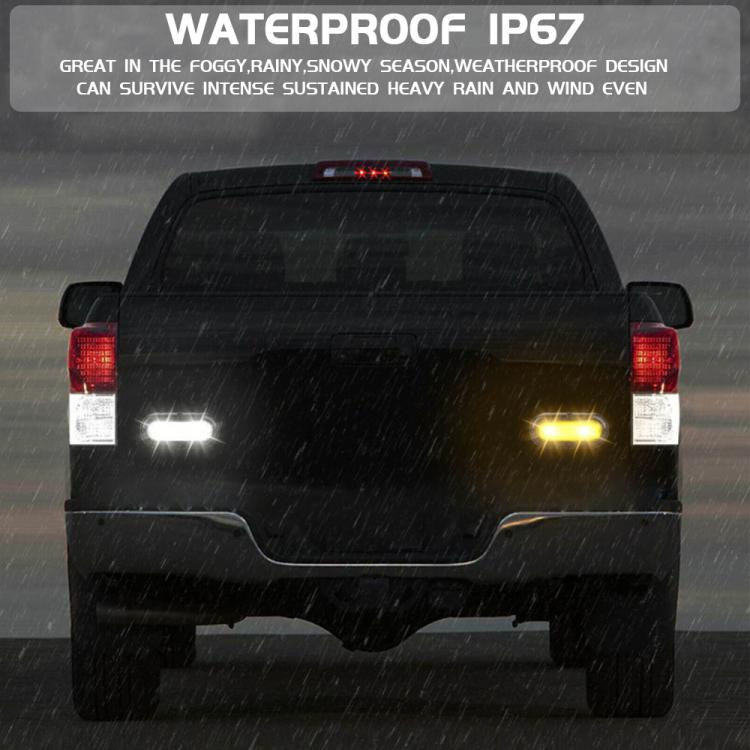 Flashing LED trailer taillights mounted on vehicle, showing yellow and red glow