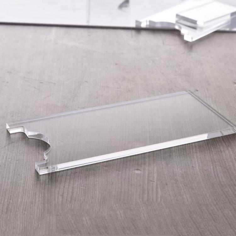 Clear acrylic sofa leg floor gasket with curved notch over smooth floor surface