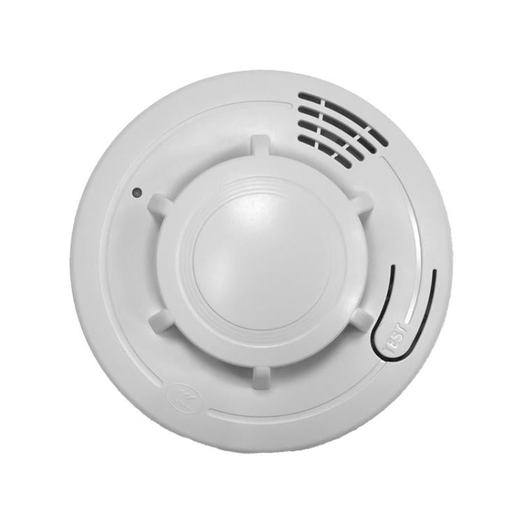 White circular smoke alarm detector with test button and speaker grille vents