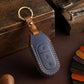 Blue genuine leather car key cover with tan strap, brass keyring, and stitched button icons