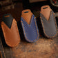 Set of genuine leather car key covers in brown, blue, and dark gray with stitched edges