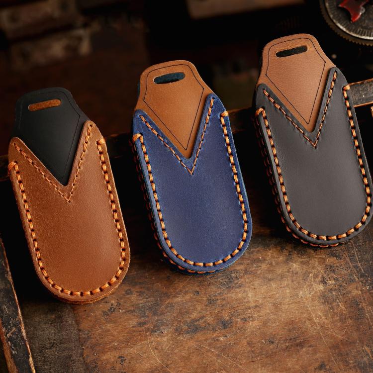 Set of genuine leather car key covers in brown, blue, and dark gray with stitched edges
