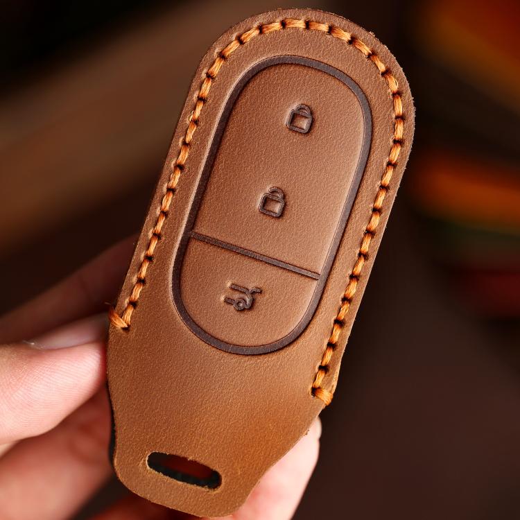 Brown genuine leather car key cover with embossed button icons and edge-stitching