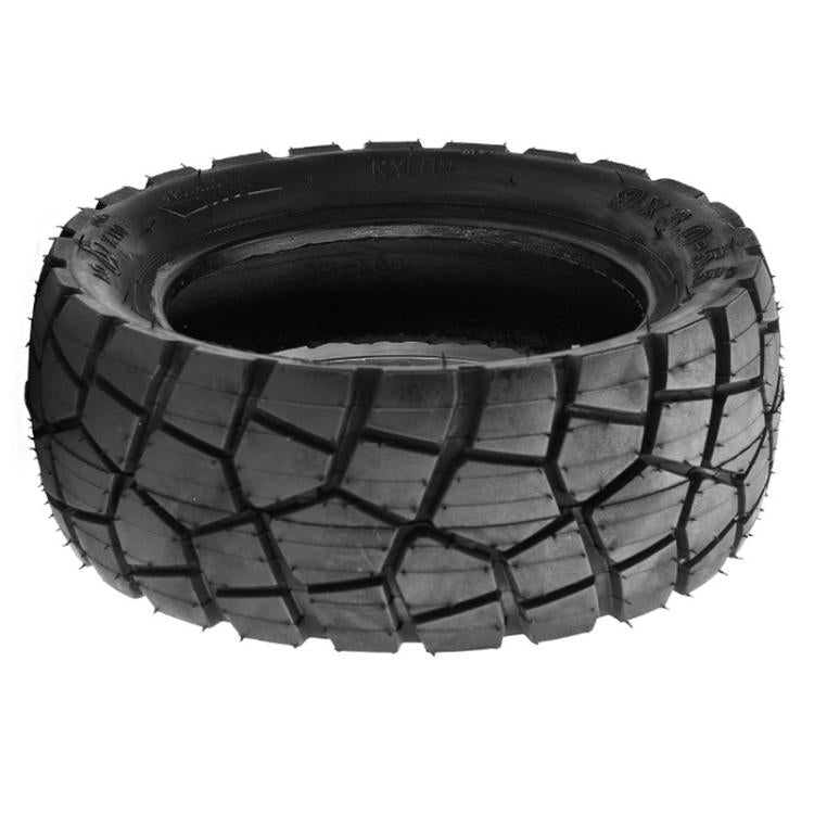 Black off-road tubeless scooter tire with chunky tread pattern and wide sidewall