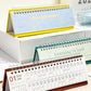 Close-up of 2026 mini desk calendars with spiral rings, blue and teal covers