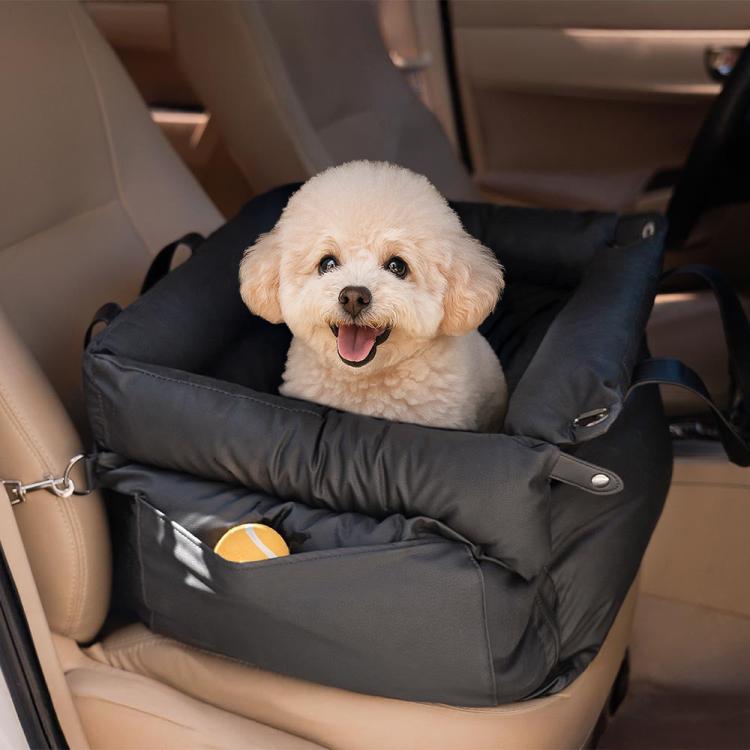 Black pet car seat bed with padded walls and clips, small dog lying inside