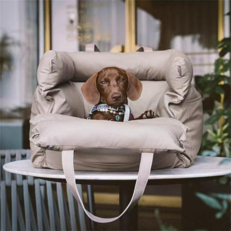 Light gray pet car seat bed with thick bolsters and shoulder straps, resting dog