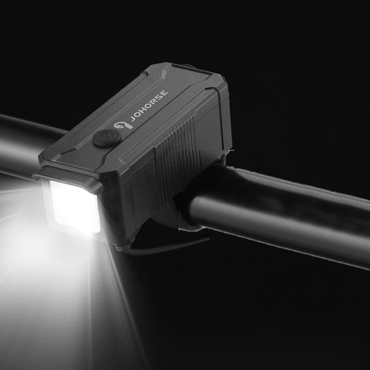 Black bicycle headlight on handlebar showing bright beam to the left