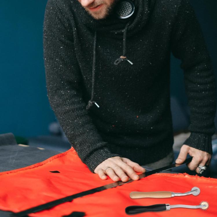 Tailoring marking wheel tool in use on fabric with person holding tool and fabric