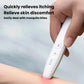 Infrared anti-itch pen pressed to skin with glowing pink heating tip