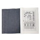 Open embroidery stitch book with dark cover and stitched motif on cream page