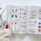 Embroidery stitch book open flat with hand holding; colorful stitch panels