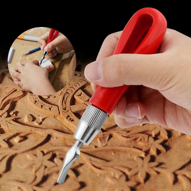 Red-handled engraving knife held above carved wooden design with silver blade tip