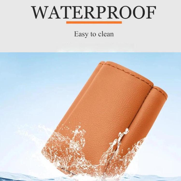 Orange leather car seat belt buckle protector cover with water droplets on surface.
