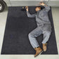 Large dark charcoal felt garage mat laid on concrete for car repairs