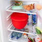Red silicone mixing bowl lid storing food in refrigerator