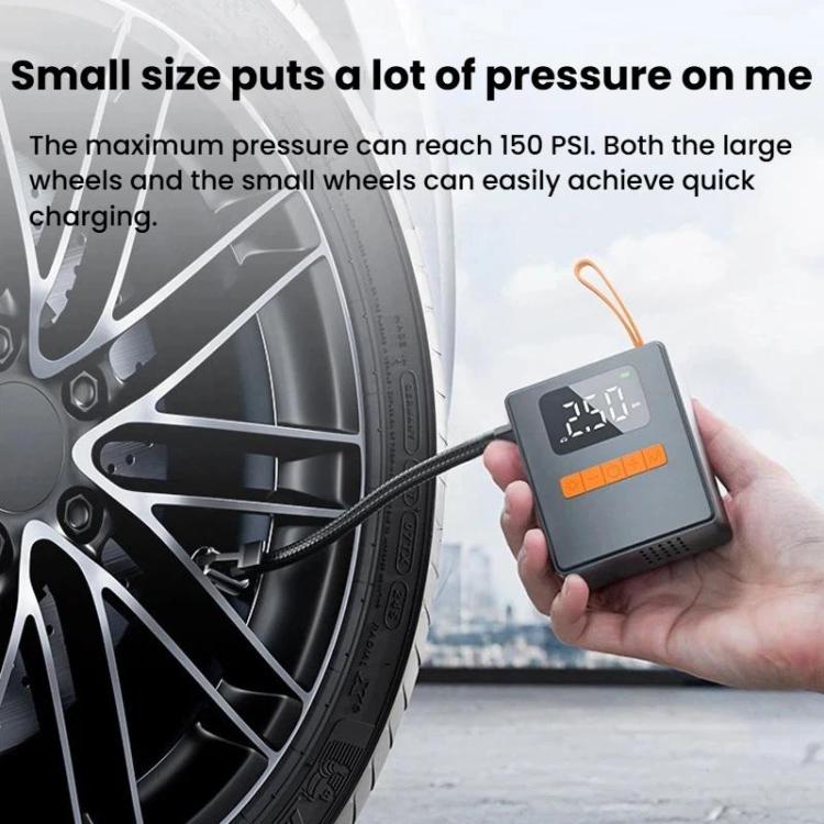 Portable tire inflator held in hand next to a car wheel with mounted air hose