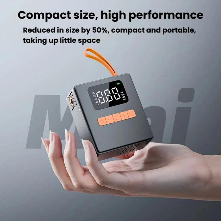 Compact portable digital tire inflator with LCD display and orange handle, carried in hand