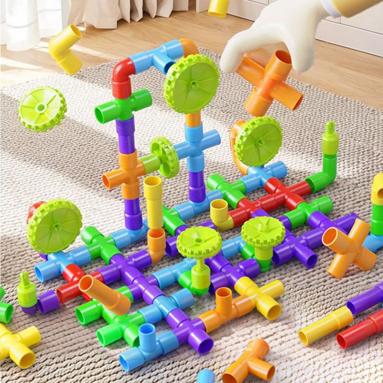 Children pipe building blocks set close-up of colorful pipe-wheel structures on mat