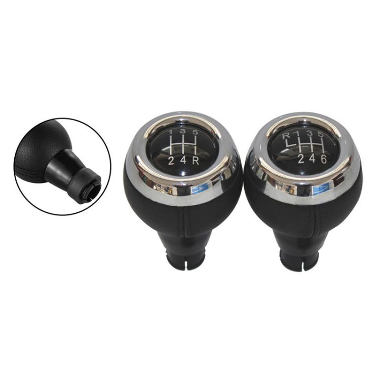 Pair of black leather manual shift knobs with chrome bezels and visible gear markings