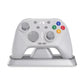 White mechanical game controller on a charging stand base with colorful face buttons