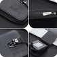 Black compact wallet close-up: metal clasp, zip pull, and embossed brand logo