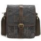 Deep gray waxed canvas crossbody bag with leather cross strap and front buckle
