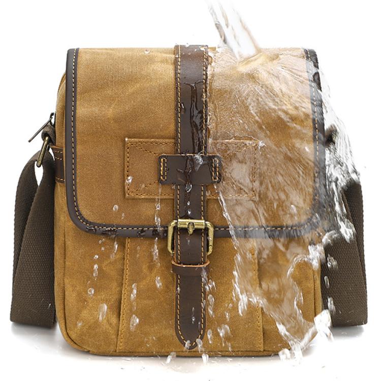 Dusty yellow waxed canvas crossbody bag with cowhide-style overlay and front buckle