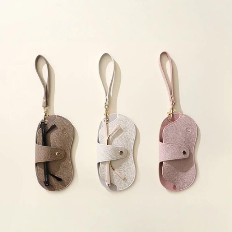Three hanging PU leather eyeglasses cases with wrist straps in brown, white, and pink