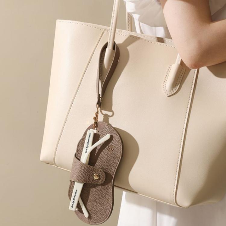 Brown hanging eyeglasses case with wrist strap attached to a tote bag