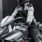 Black motorcycle rain suit on a rider holding the handlebars in rainy weather