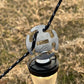 Stainless steel no-knot rope clip holding black camping cord