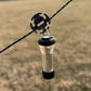 Round stainless steel rope clip securing black cord to gear