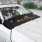 Black windshield wiper dust cover on car windshield holding fallen leaves and debris
