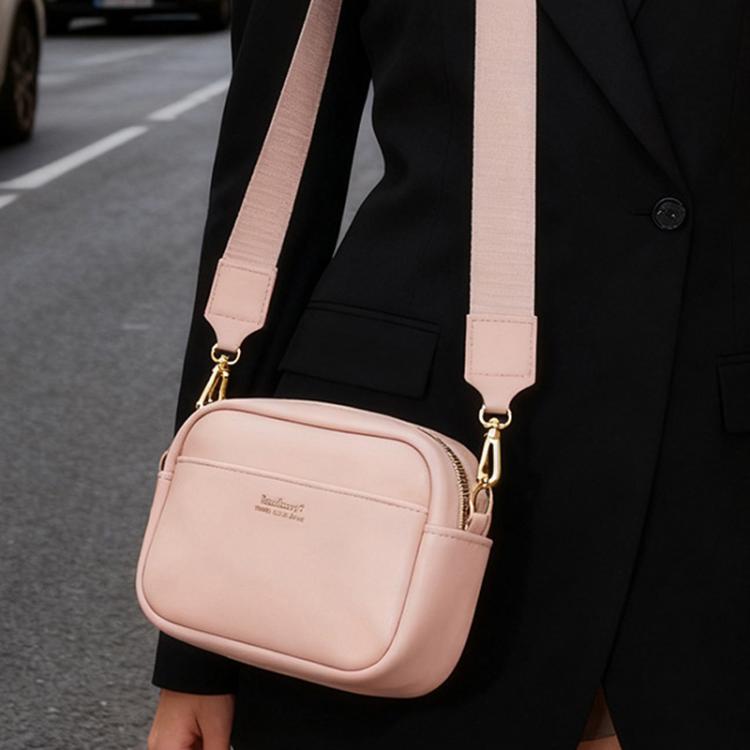 Pink square zippered crossbody pouch worn with adjustable strap and gold-tone hardware.
