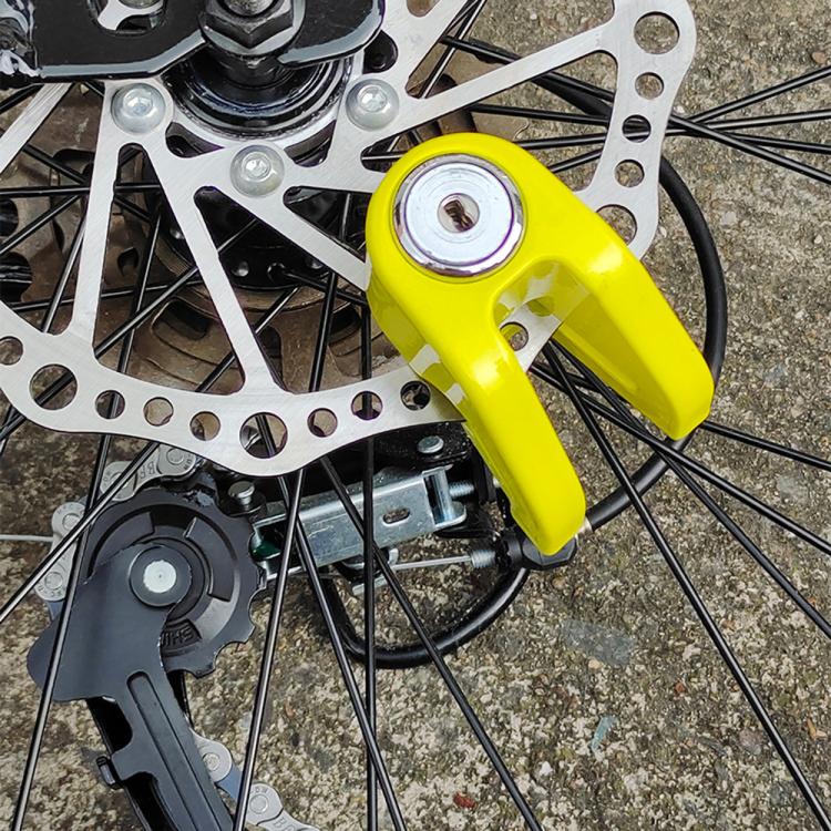 Yellow disc brake lock clamped to bike rotor with keys attached