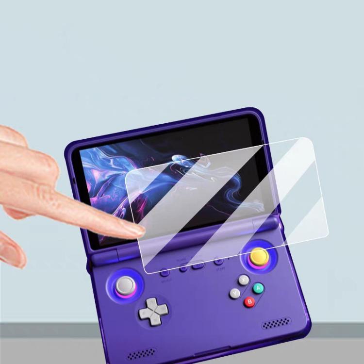 Hand aligning clear tempered glass screen protector on handheld console screen.