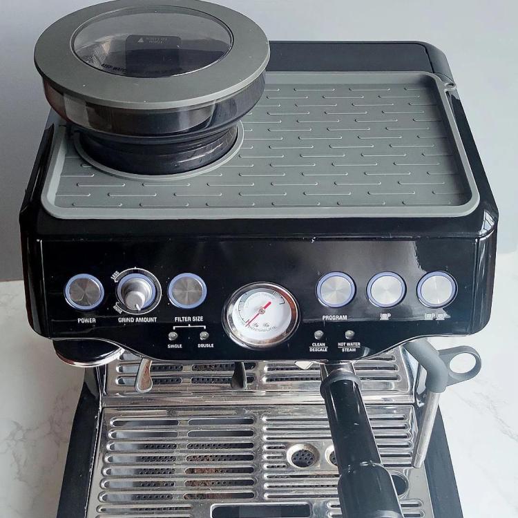 Silicone mat placed on espresso machine top, ribbed tray with circular opening