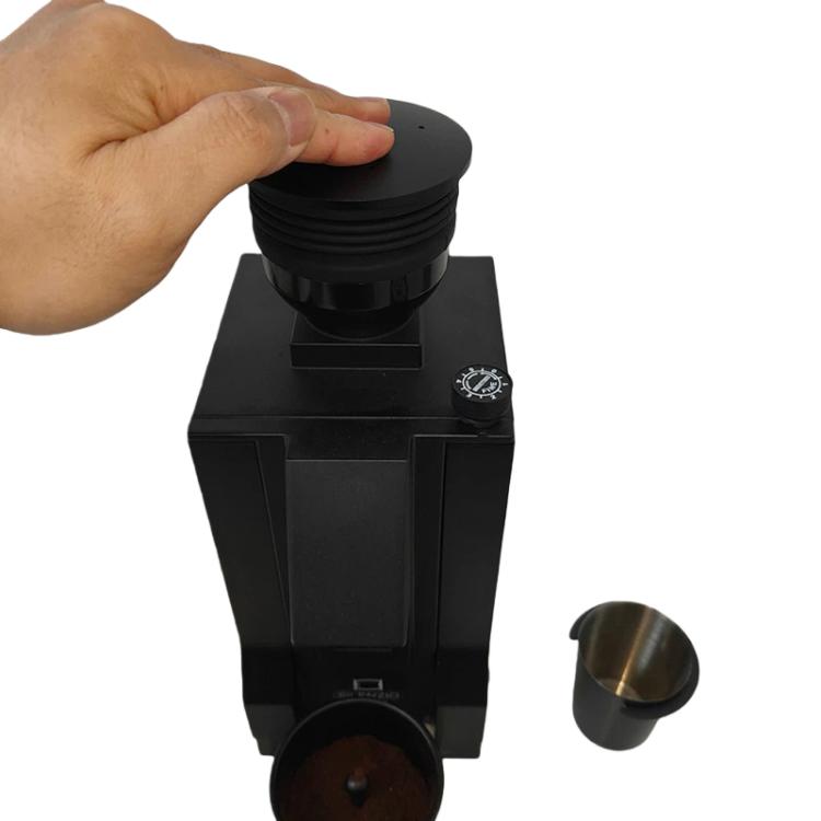 Hand removing black round lid from bean hopper air blower attachment