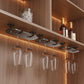 Under-cabinet stemware hanging rack with clear wine glasses under metal bar