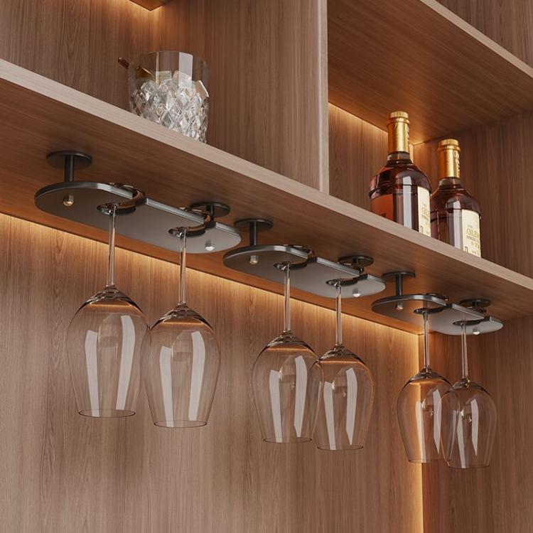 Under-cabinet stemware hanging rack with clear wine glasses under metal bar