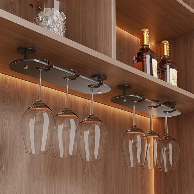 Under-cabinet stemware rack with clear hanging wine glasses on dark metal mounts