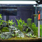 Stainless steel submersible aquarium heater with orange top mounted inside fish tank
