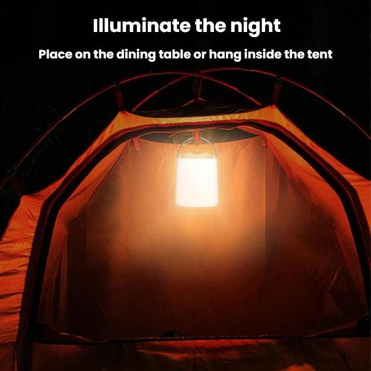 Portable camping lantern light glowing warm white inside a tent