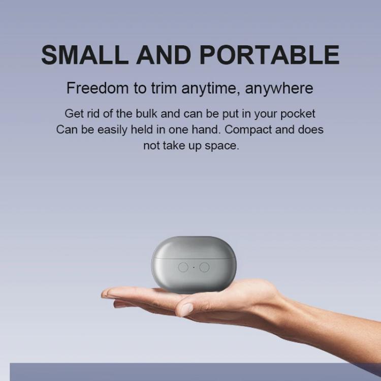 Small portable electric nail clipper held in hand, closed flip cover
