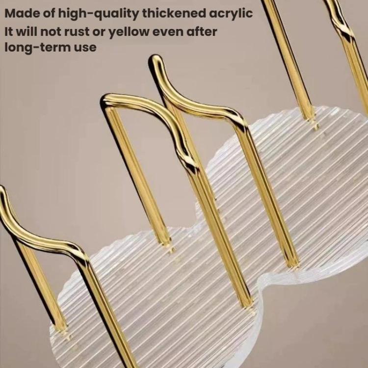 Gold acrylic cup holder frame with curved handles over a clear ridged base