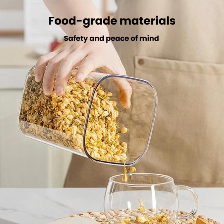 Clear food storage container with lid, hand scooping dry grains into a glass bowl