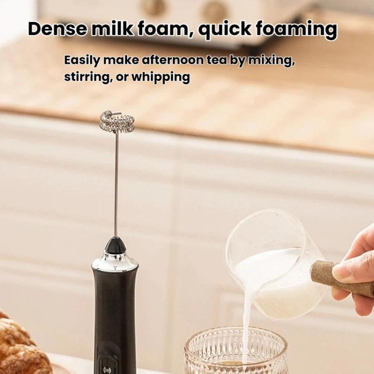 Black milk frother with balloon whisk attachment pouring into a cup